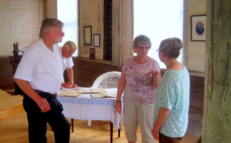Arlene, pictured on right, discusses the restoration with guests. Original church books are displayed on the table.